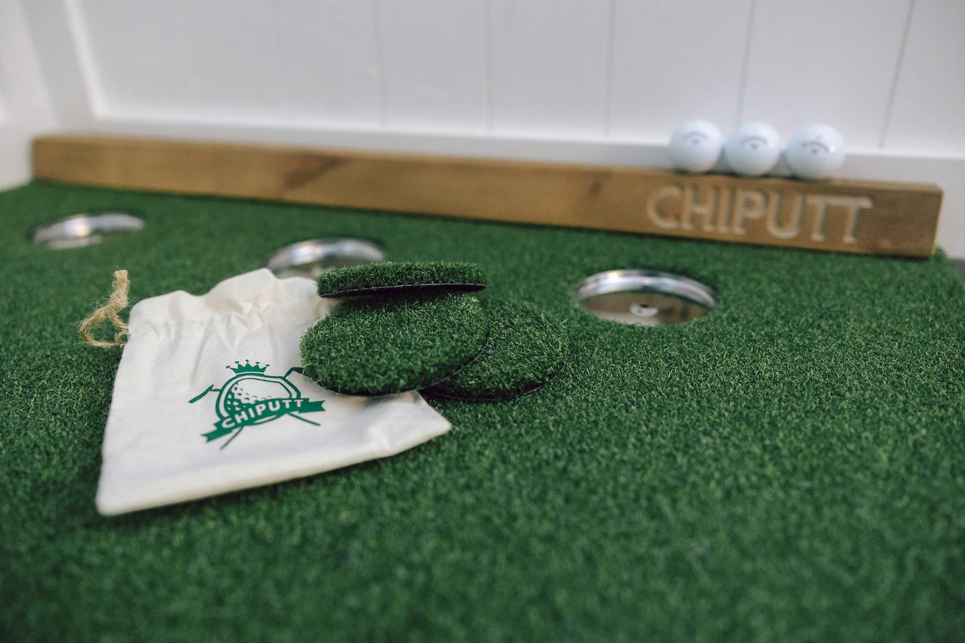 Sprzęt Chiputt na zielonym dywanie do ćwiczeń puttowania w pomieszczeniu