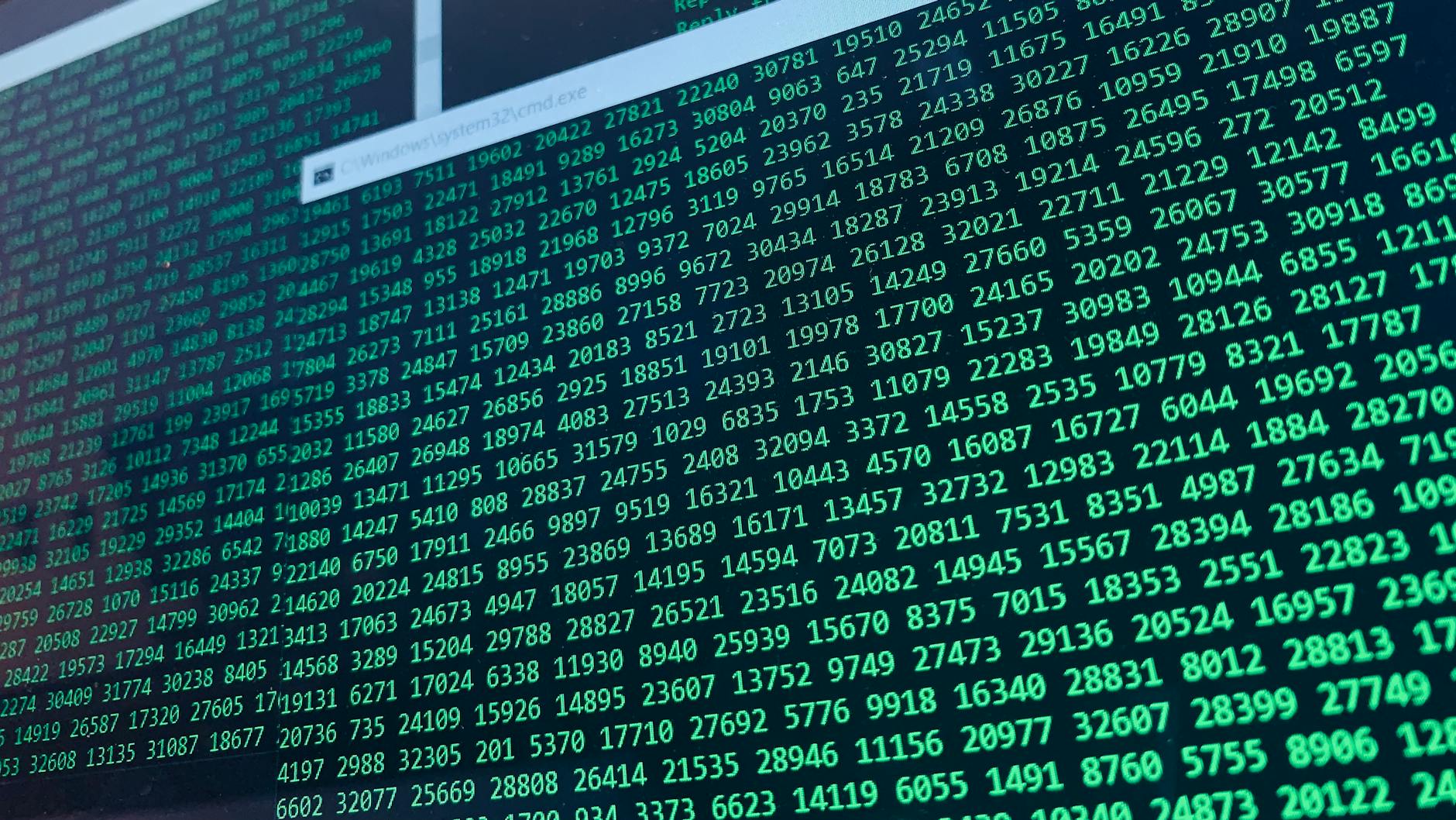 Zielone cyfry binarne na ekranie komputera symbolizujące szyfrowanie danych