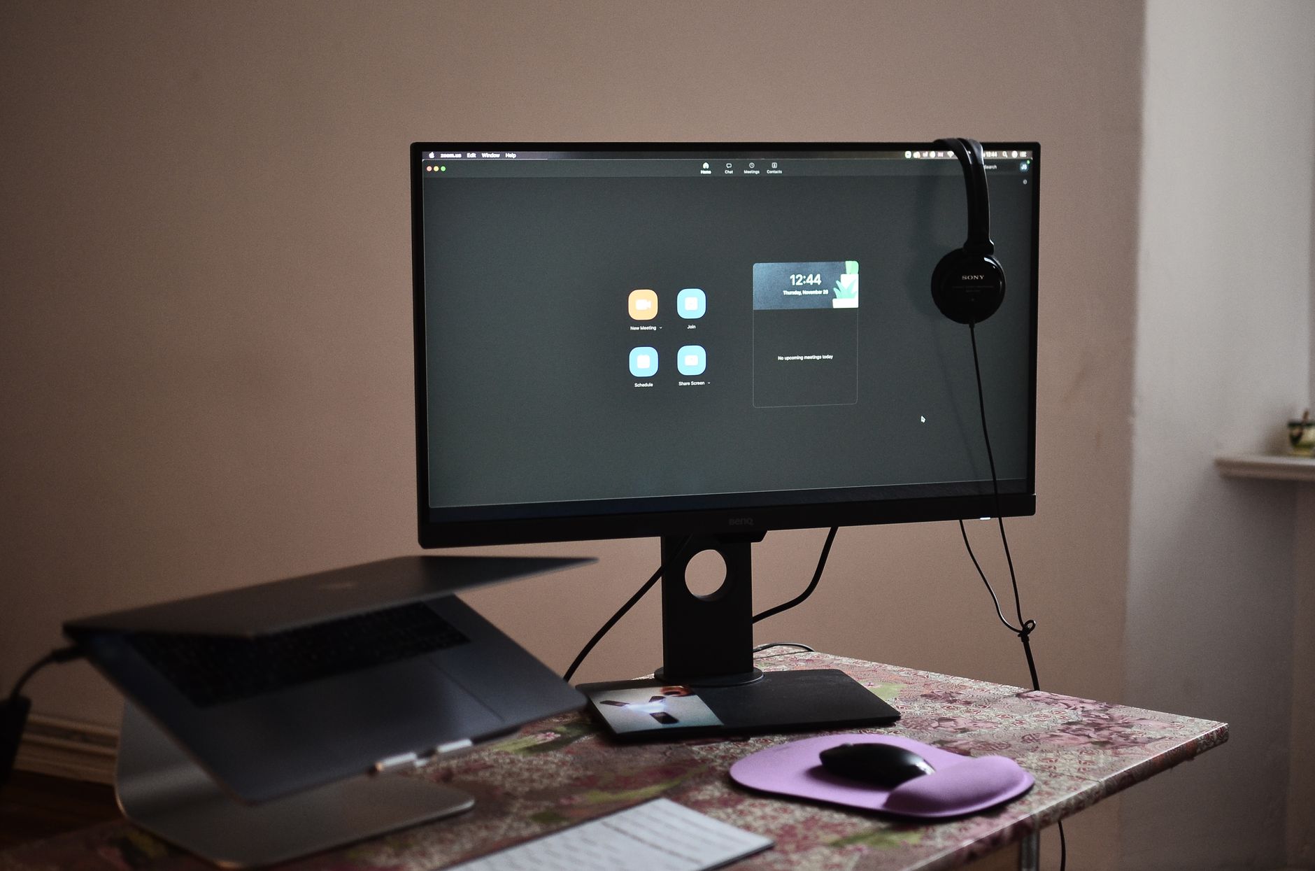 Biurko z monitorem, słuchawkami i laptopem w ergonomicznym stanowisku pracy