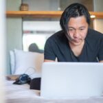 Porównanie trybów koncentracji w najpopularniejszych systemach: iOS, Android, Windows i macOS kontra rozproszenie Mężczyzna pracujący w domu przy laptopie, skupiony na ekranie