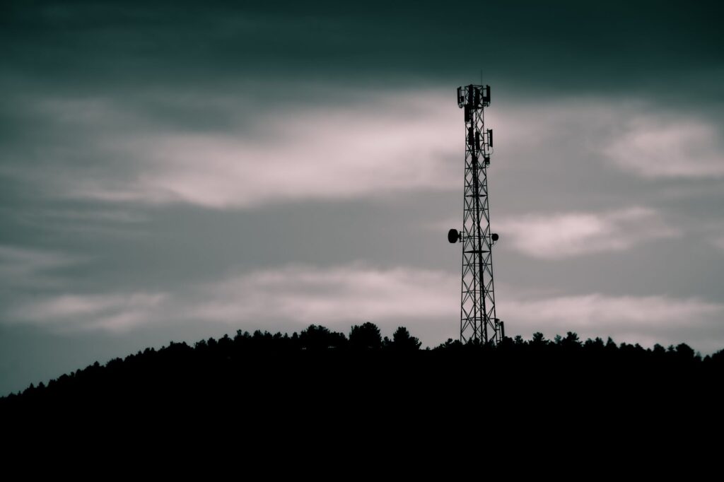 Sylwetka masztu telekomunikacyjnego na tle nieba o zmierzchu